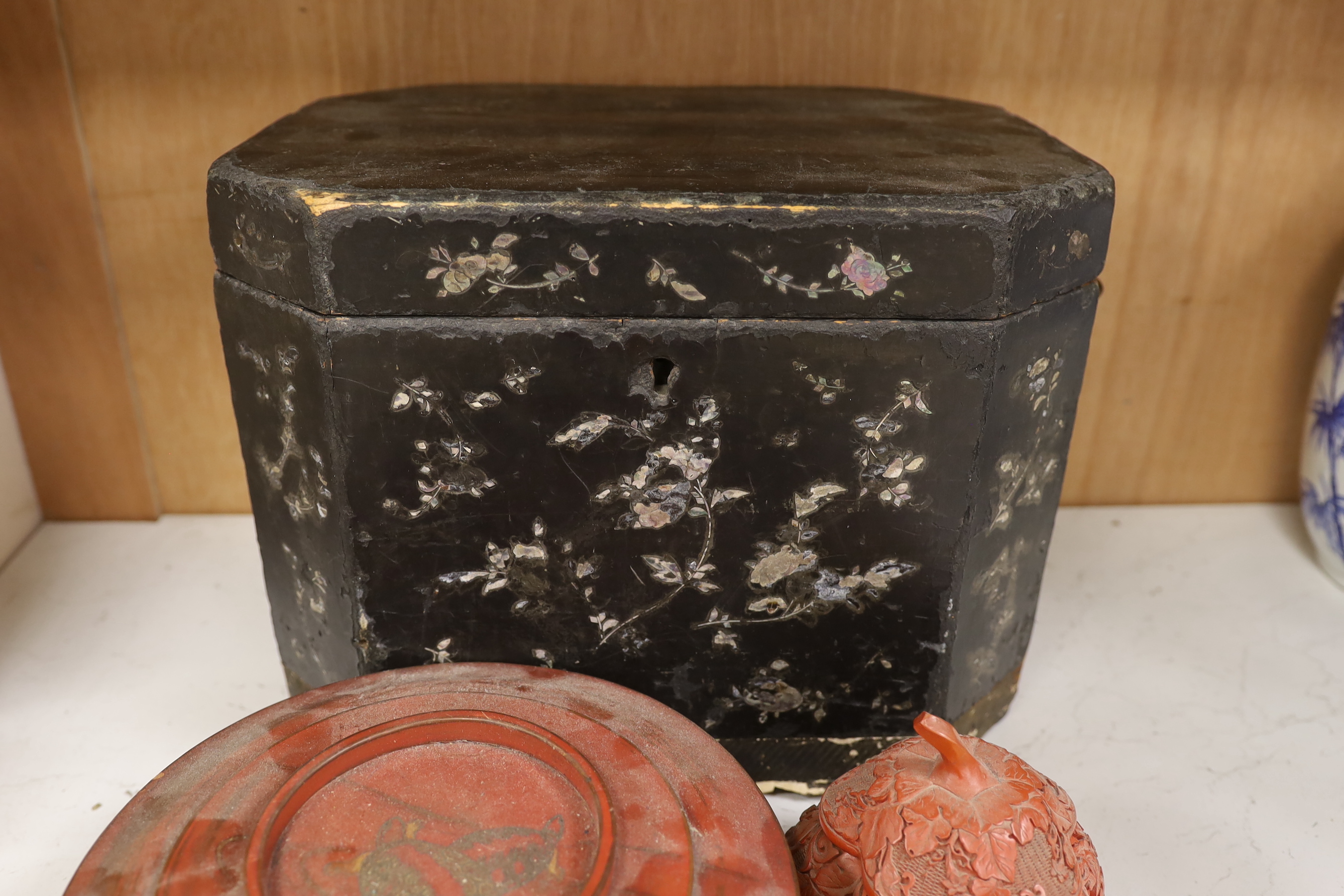 A Chinese black lacquer and mother of pearl box, two red lacquer boxes and a Chinoiserie painted box, largest 28cm wide, 37cm high